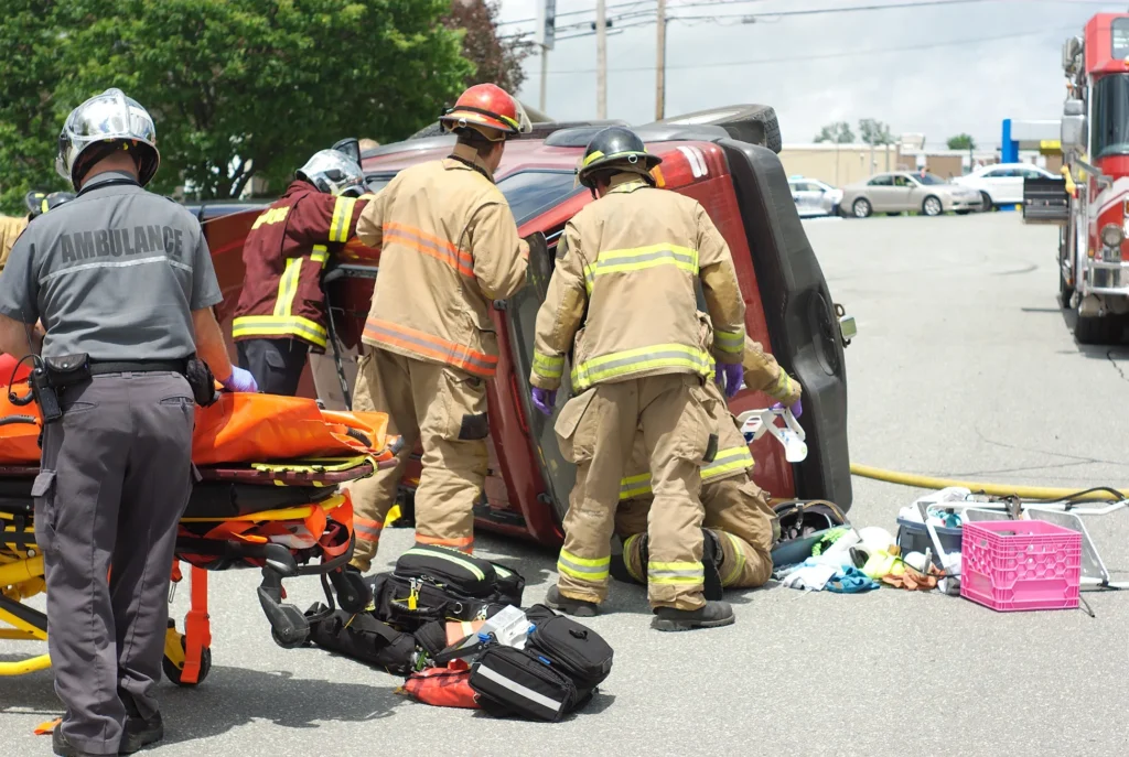 Firefighters surrounding an overturned truck.