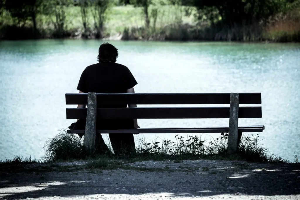 A lonely person sitting on a park bench.