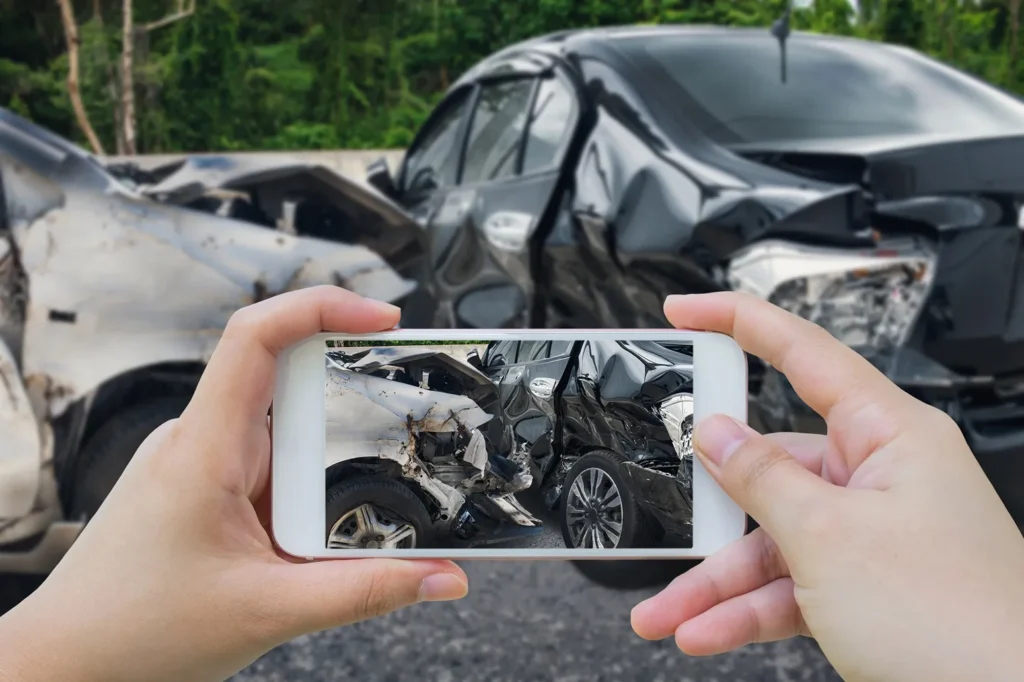Taking a picture of a car accident.