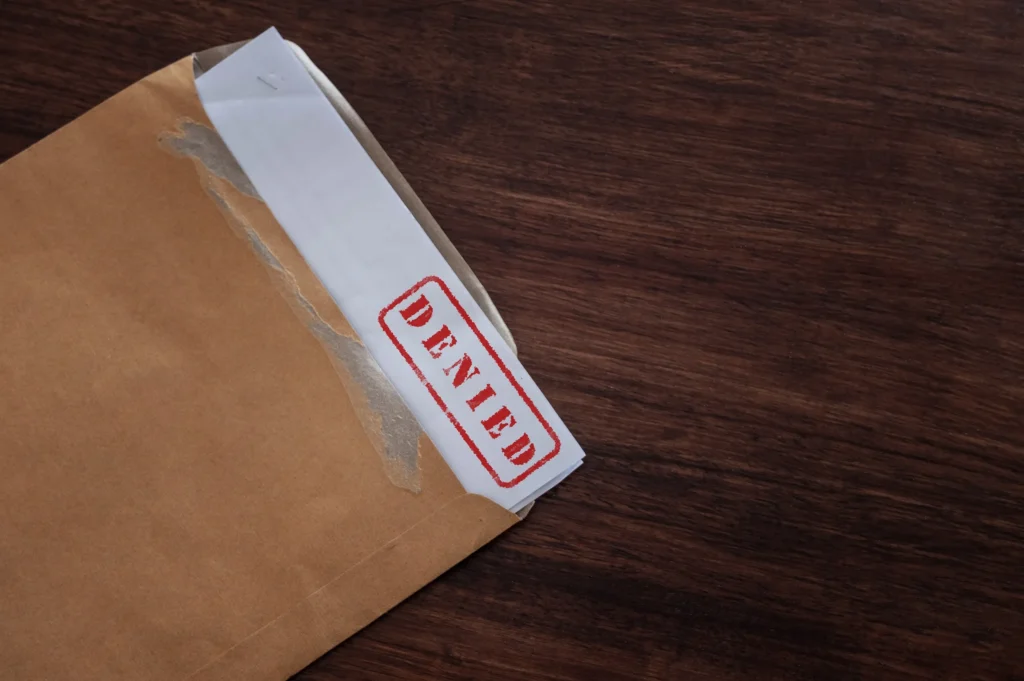 paperwork with Denied stamped on it.