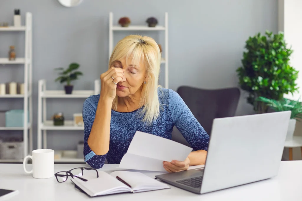 A distressed woman looking at paperwork.