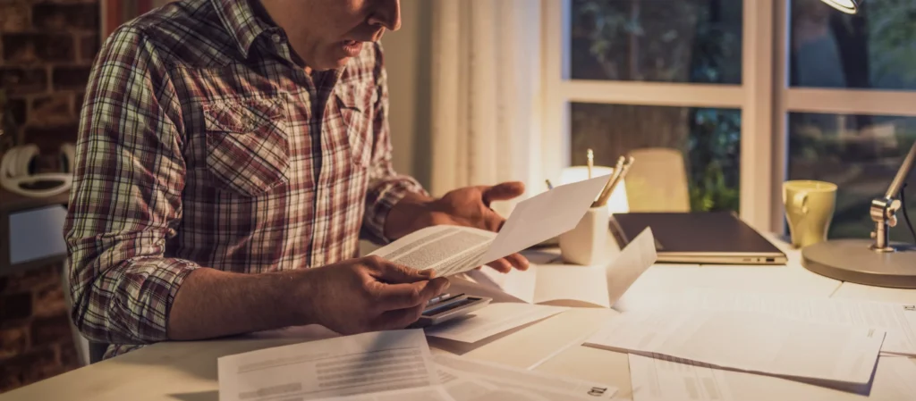 A man reading a letter from his insurance.