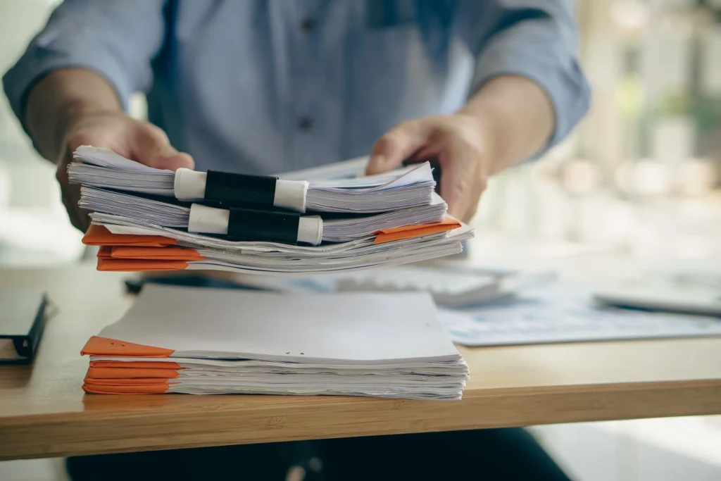 A man setting down a pile of paperwork.